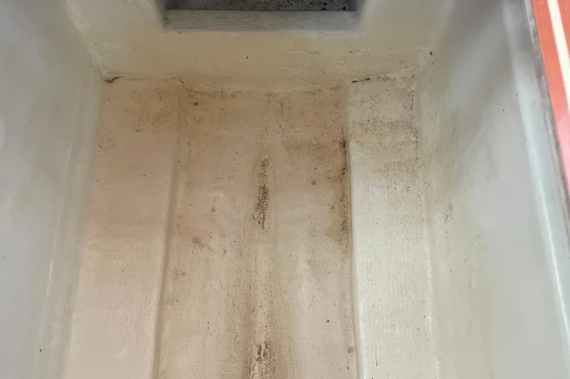 Slide: The Image of Interior of a 2008 Hunter 49 boat compartment, showing a clean, empty storage area. - 36