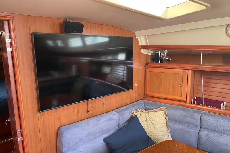 Slide: The Image of Interior of 2008 Hunter 49 yacht with TV, wooden cabinetry, and cushioned seating. - 37