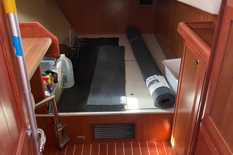 Slide: The Image of Interior of a 2008 Hunter 49 sailboat with cleaning supplies and rolled carpet. - 46