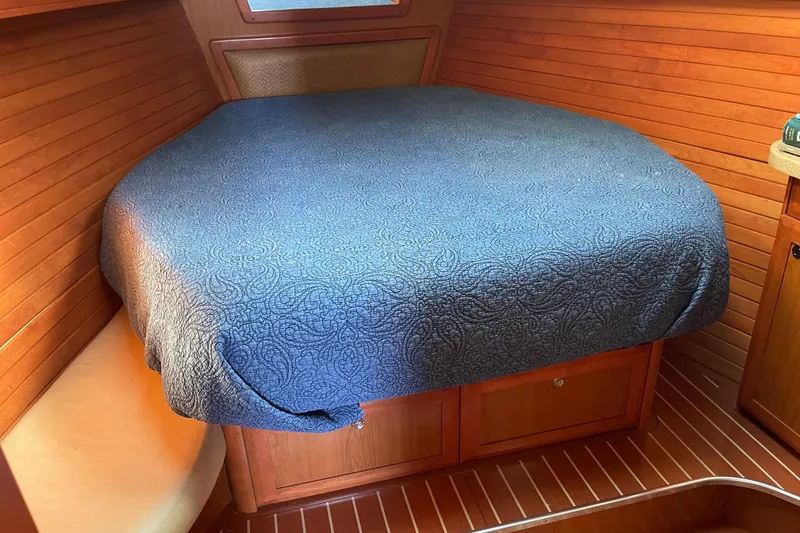 Slide: The Image of Cozy cabin interior of 2008 Hunter 49 yacht with blue bedspread and wooden paneling. - 5