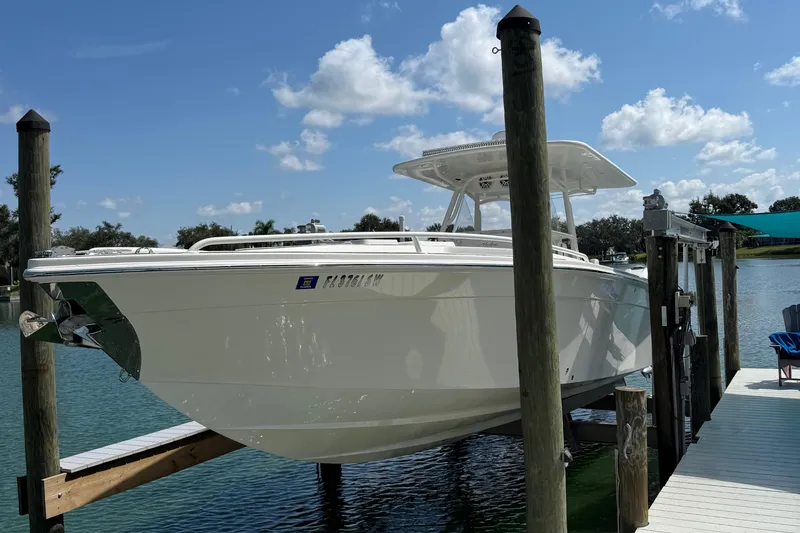 Slide: The Image of 2005 Marlago 35 boat docked on a lift under a clear blue sky. - 22