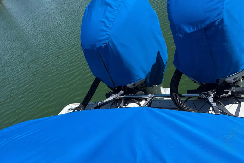 Slide: The Image of Covered engines on a 2005 Marlago 35 boat, docked on calm water. - 27