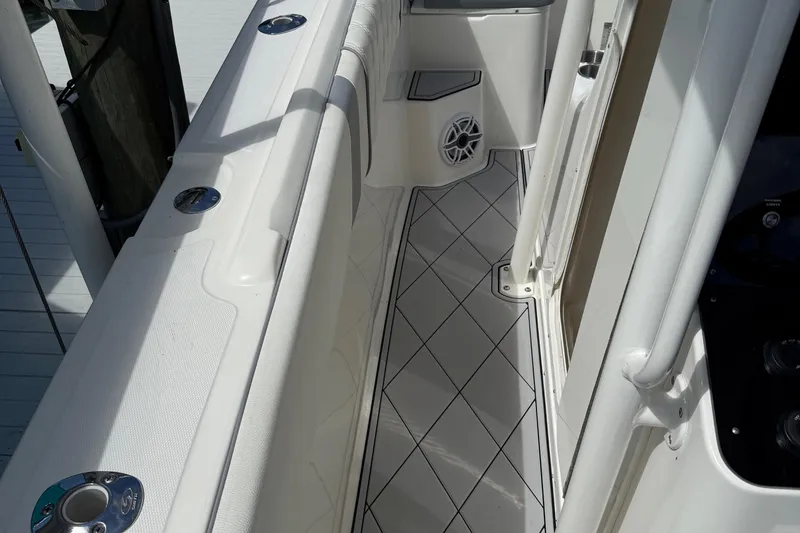 Slide: The Image of Interior view of a 2005 Marlago 35 boat, featuring sleek white design and diamond-patterned flooring. - 37