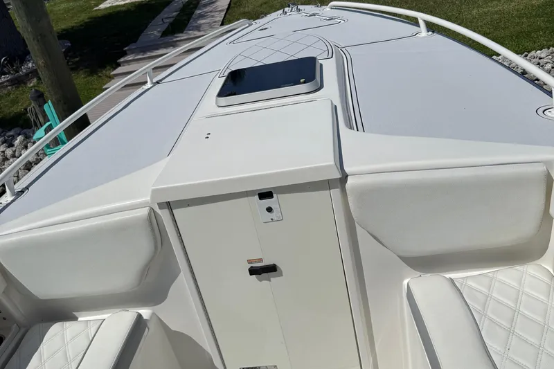 Slide: The Image of 2005 Marlago 35 boat interior with white seating and storage compartment. - 46