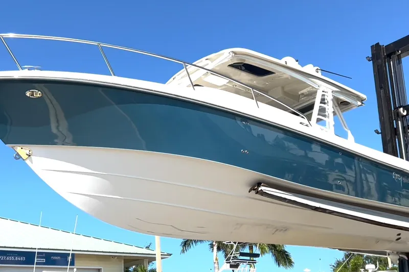 Slide: The Image of 2017 Everglades 360LXC boat with blue hull, displayed outdoors under clear sky. - 13