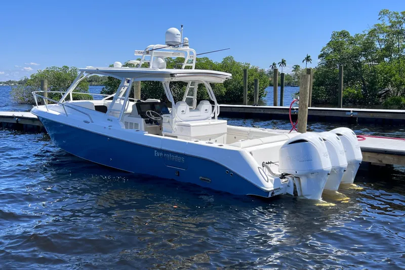 Slide: The Image of 2017 Everglades 360LXC boat docked, featuring triple outboard engines and sleek design. - 15