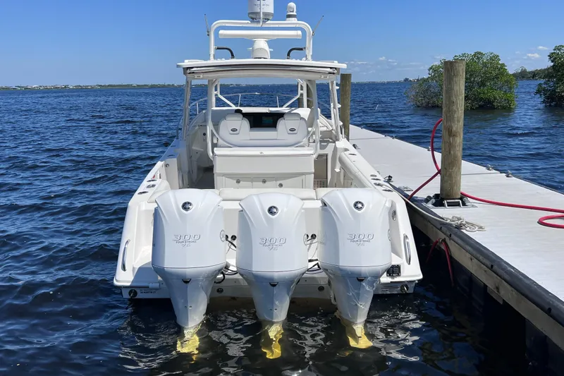 Slide: The Image of 2017 Everglades 360LXC boat docked, featuring triple 300 horsepower outboard engines. - 16