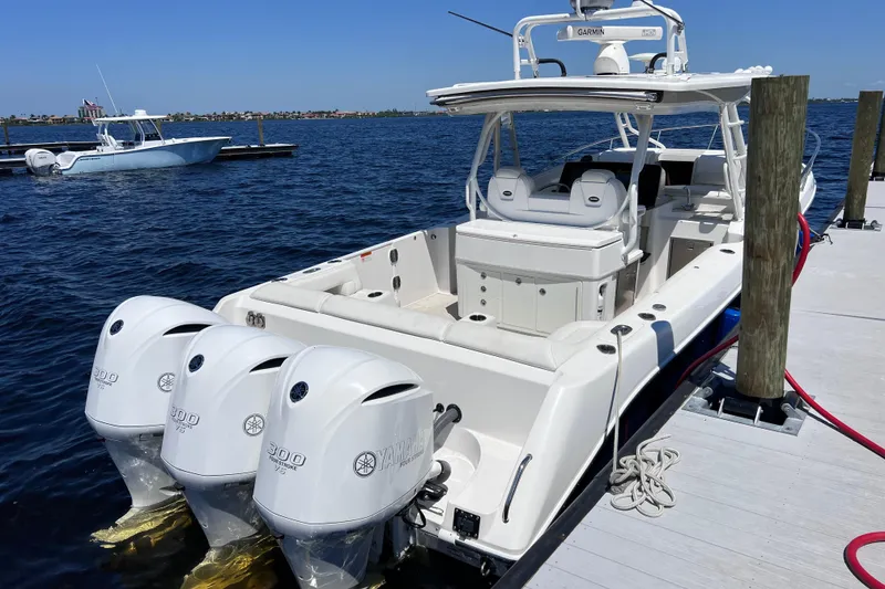 Slide: The Image of 2017 Everglades 360LXC boat docked, featuring triple Yamaha 300 outboard engines. - 17