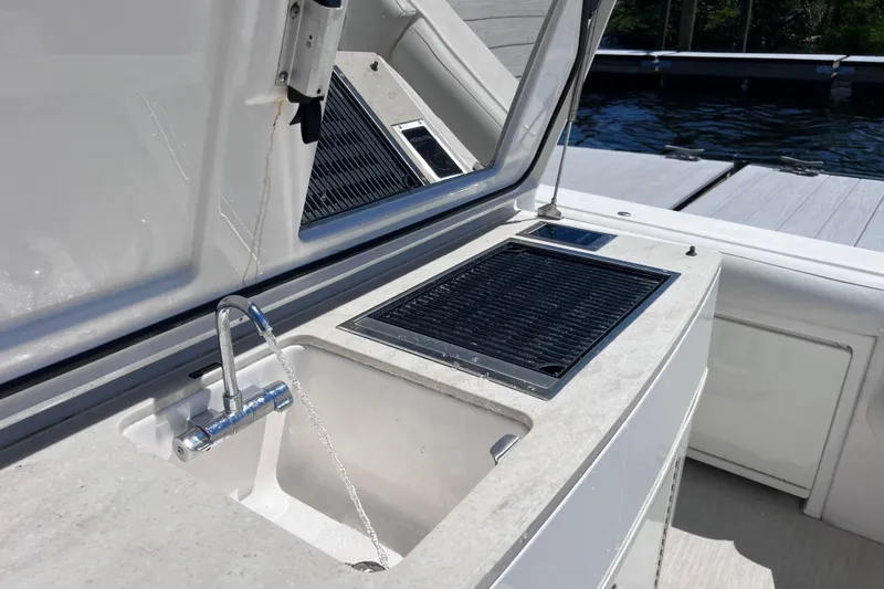 Slide: The Image of Outdoor sink and grill on 2017 Everglades 360LXC boat, dockside view. - 26