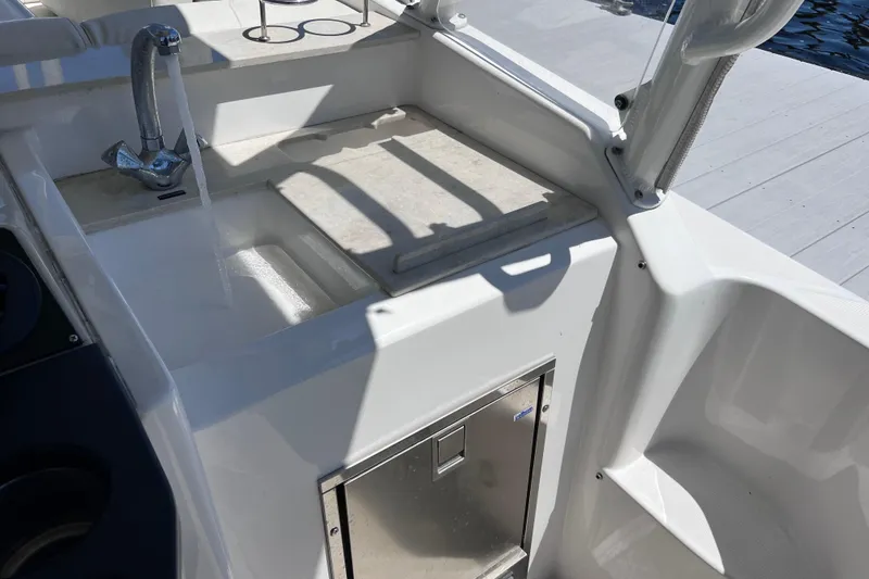 Slide: The Image of 2017 Everglades 360LXC boat sink area with faucet and storage compartment. - 30