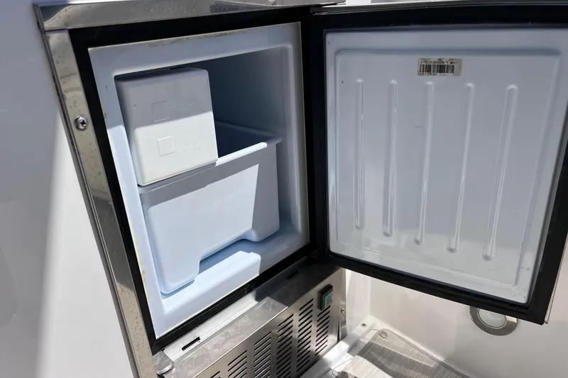 Slide: The Image of Open refrigerator on 2017 Everglades 360LXC boat, showing interior storage space. - 31