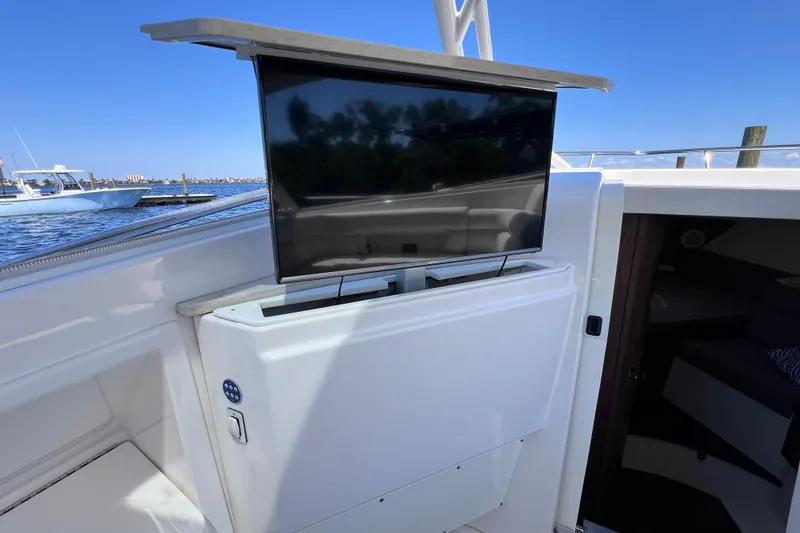 Slide: The Image of 2017 Everglades 360LXC boat with a retractable TV on deck, docked by the water. - 73