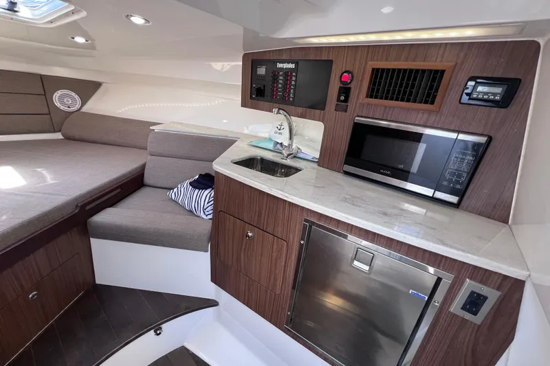Slide: The Image of 2017 Everglades 360LXC cabin interior with kitchenette, microwave, and seating area. - 77