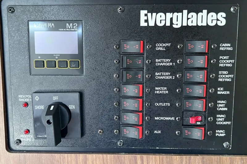 Slide: The Image of Electrical control panel of 2017 Everglades 360LXC boat with labeled switches and multimeter. - 84