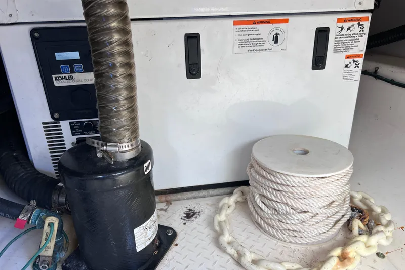 Slide: The Image of Engine compartment of 2017 Everglades 360LXC with generator and coiled rope. - 91