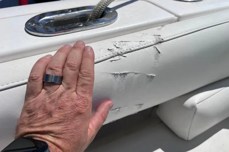 Slide: The Image of Hand inspecting damaged upholstery on 2017 Everglades 360LXC boat. - 96