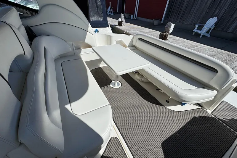 Slide: The Image of 2004 Sea Ray 360 Sundancer interior with white seating and table on deck. - 13