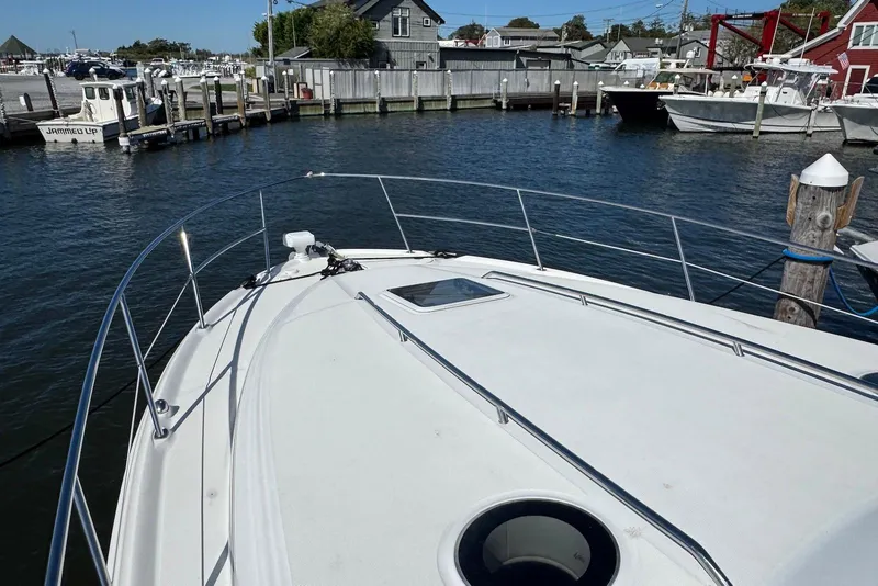 Slide: The Image of 2004 Sea Ray 360 Sundancer yacht docked in a marina, showcasing its spacious deck. - 15