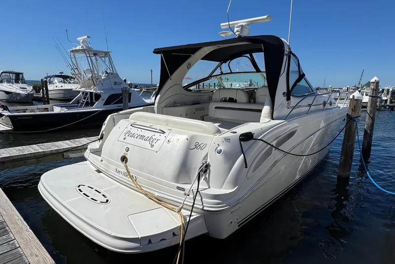 Slide: The Image of 2004 Sea Ray 360 Sundancer docked at marina, rear view with open cockpit. - 2