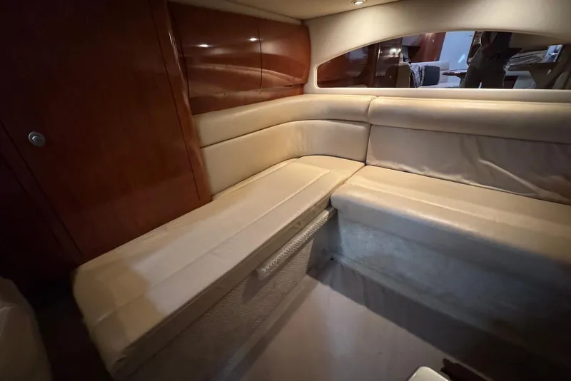 Slide: The Image of 2004 Sea Ray 360 Sundancer interior with beige seating and wooden paneling. - 25