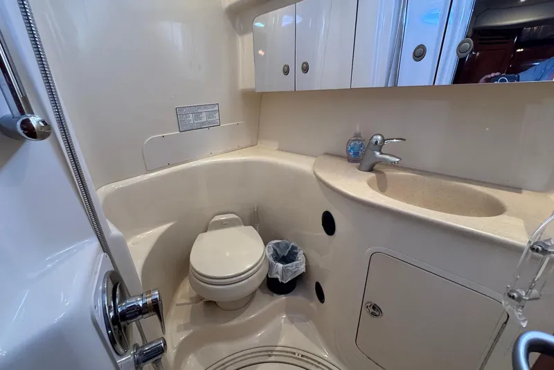Slide: The Image of 2004 Sea Ray 360 Sundancer bathroom with toilet, sink, and storage cabinets. - 27