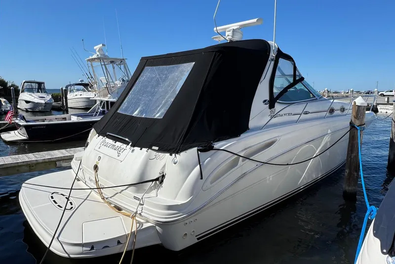 Slide: The Image of 2004 Sea Ray 360 Sundancer docked at marina, featuring sleek design and black canopy. - 3