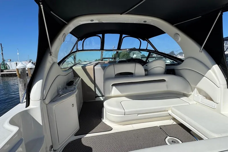 Slide: The Image of 2004 Sea Ray 360 Sundancer boat interior with white seating and canopy, docked at marina. - 6