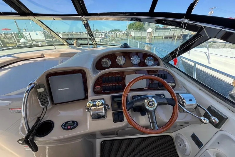 Slide: The Image of 2004 Sea Ray 360 Sundancer helm with steering wheel, gauges, and navigation equipment. - 9