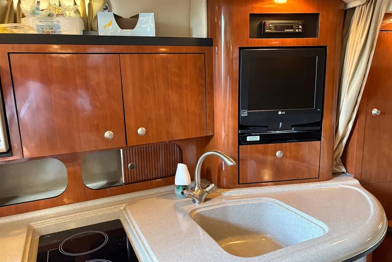 Slide: The Image of Interior of 2007 Sea Ray 340 Sundancer with wood cabinetry, sink, and built-in TV. - 13