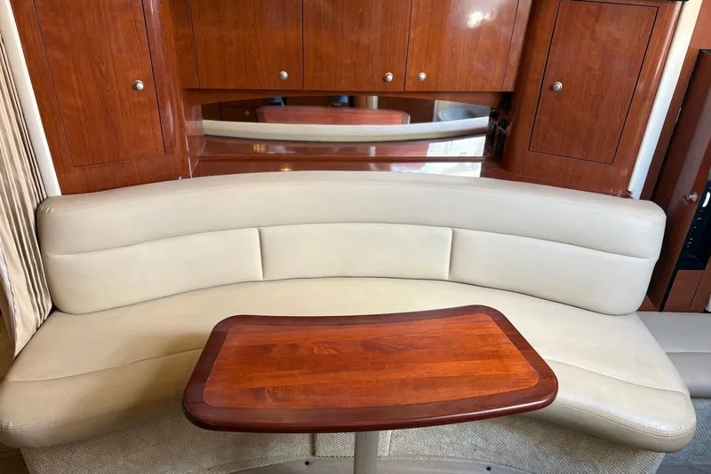 Slide: The Image of Luxurious interior of 2007 Sea Ray 340 Sundancer with curved seating and wooden table. - 17