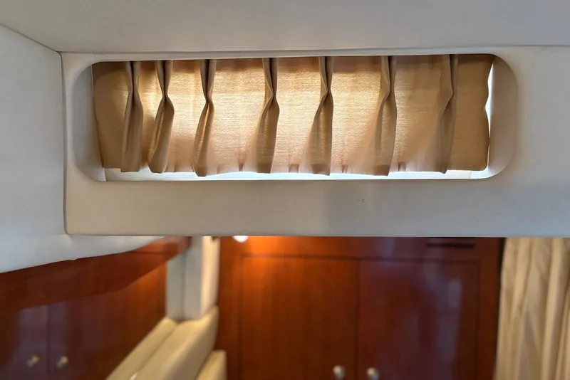 Slide: The Image of Interior of 2007 Sea Ray 340 Sundancer with wooden cabinetry and window curtain. - 18