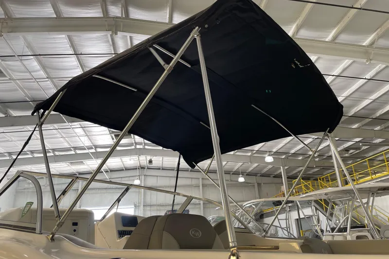 Slide: The Image of 2021 Key West 239 DFS boat with black bimini top in a showroom. - 13