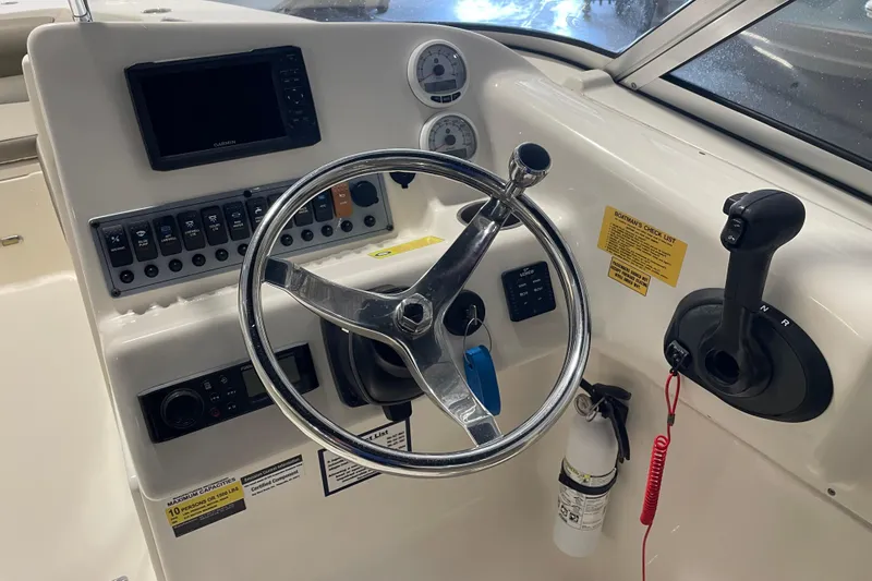Slide: The Image of 2021 Key West 239 DFS boat dashboard with steering wheel, controls, and gauges. - 21
