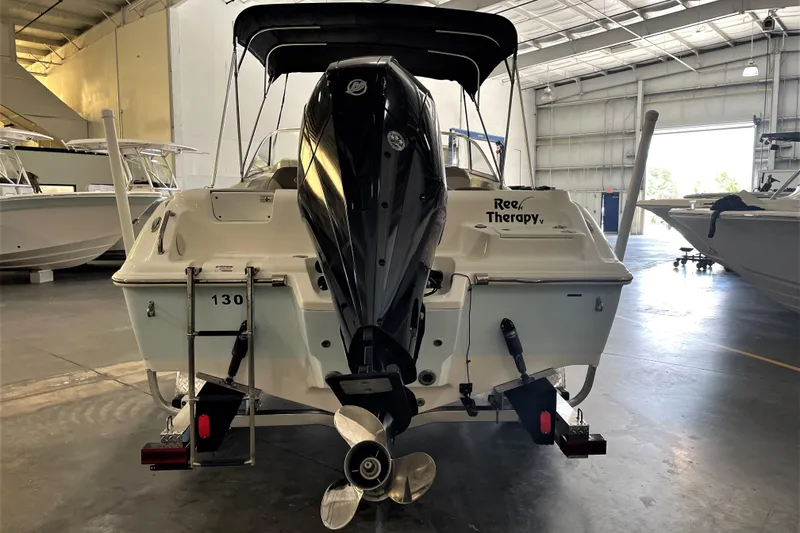 Slide: The Image of 2021 Key West 239 DFS boat in a warehouse, rear view with outboard motor. - 8