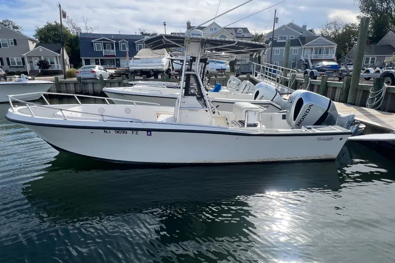 The Image of 1995 Mako 221 Center Console boat docked with twin Honda outboard engines. - 1