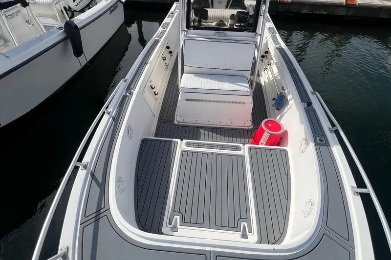 Slide: The Image of 1995 Mako 221 Center Console boat with gray deck and seating, docked in water. - 10