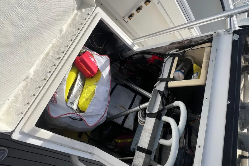 Slide: The Image of Open storage compartment on a 1995 Mako 221 Center Console boat, containing various equipment. - 12