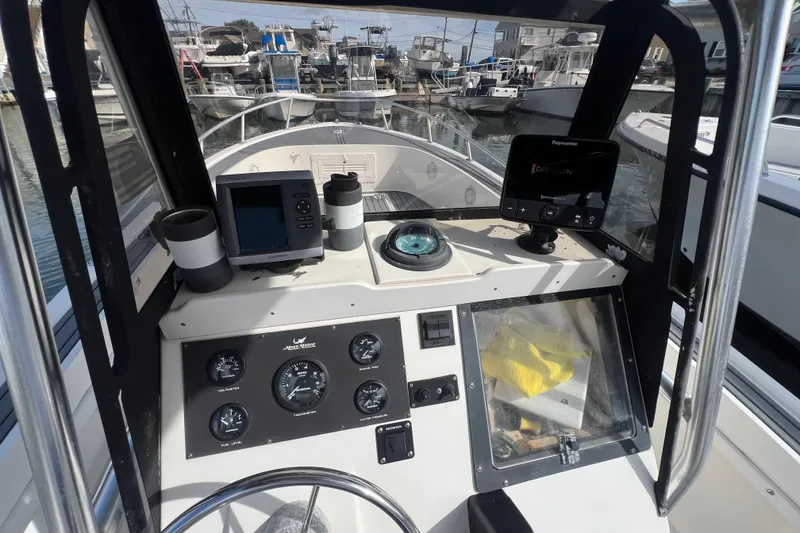 Slide: The Image of 1995 Mako 221 Center Console boat dashboard with navigation instruments and gauges. - 14