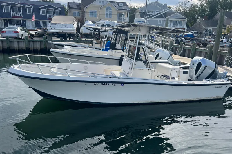 Slide: The Image of 1995 Mako 221 Center Console boat docked, featuring dual Honda outboard engines. - 2
