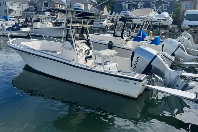 Slide: The Image of 1995 Mako 221 Center Console boat docked with Honda outboard motor. - 3