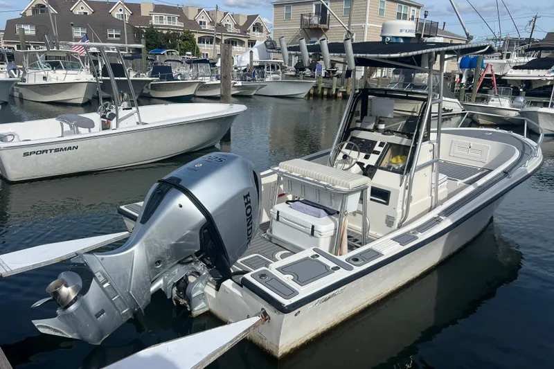 Slide: The Image of 1995 Mako 221 Center Console boat with Honda outboard motor docked at marina. - 4