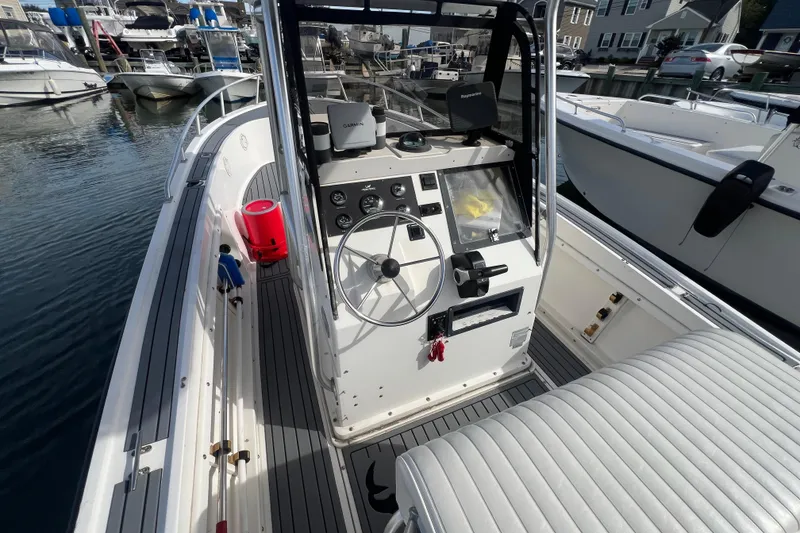 Slide: The Image of 1995 Mako 221 Center Console boat with steering wheel and navigation equipment at marina. - 7