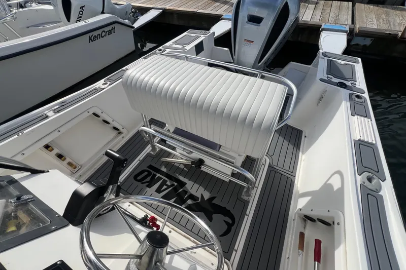 Slide: The Image of 1995 Mako 221 Center Console boat interior with steering wheel and seating at dock. - 8