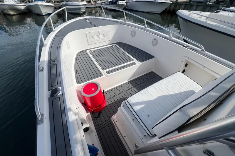 Slide: The Image of 1995 Mako 221 Center Console boat interior with seating and red bucket on deck. - 9