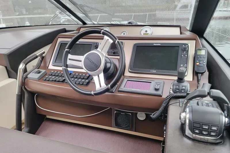 Slide: The Image of Control panel of a 2013 Prestige 500 S yacht with steering wheel and navigation equipment. - 22