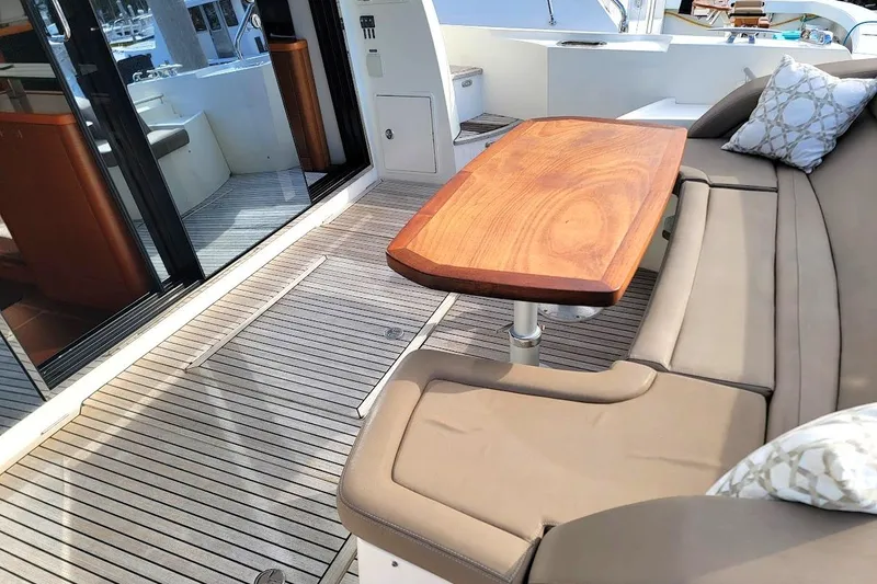 Slide: The Image of Luxurious 2013 Prestige 500 S yacht deck with elegant seating and wooden table. - 32