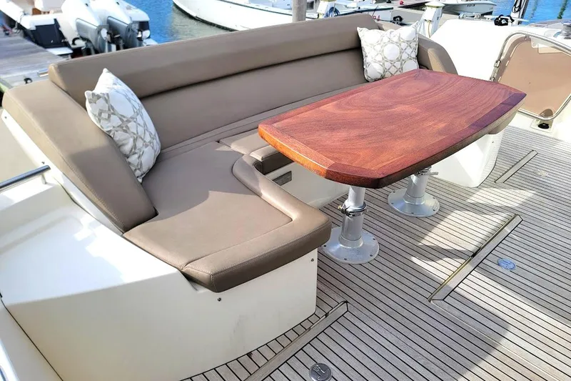 Slide: The Image of Luxurious seating area on a 2013 Prestige 500 S yacht with wooden table and cushions. - 33