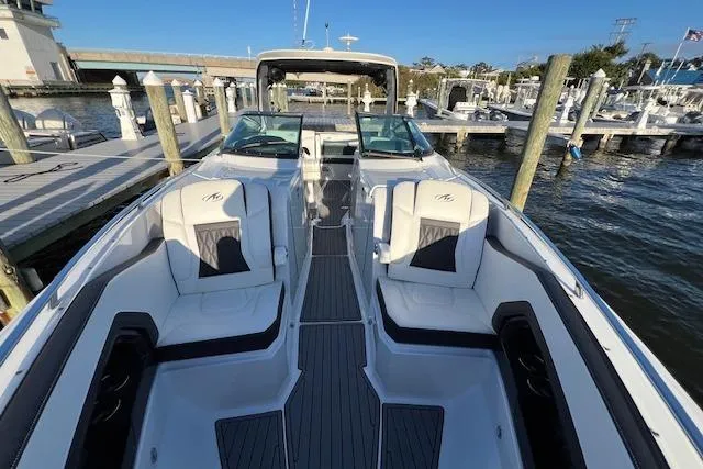 Slide: The Image of 2017 Monterey 328SS Super Sport boat docked, showcasing sleek design and spacious seating. - 5