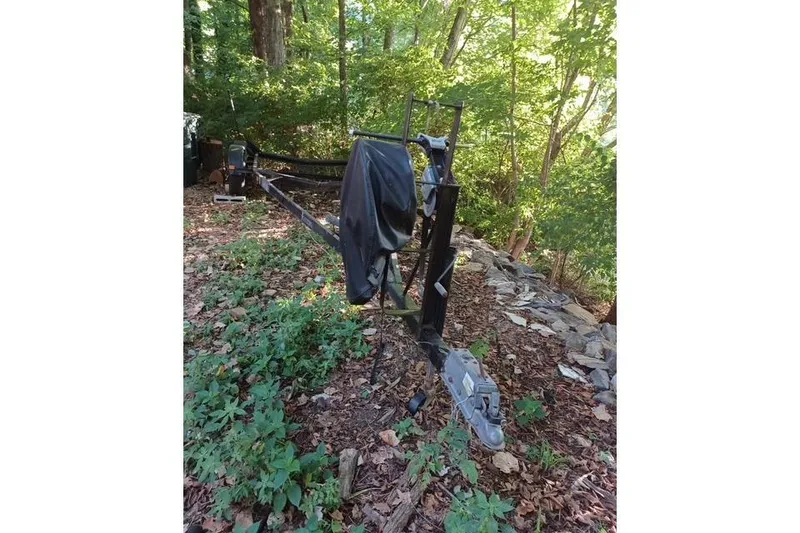 Slide: The Image of 1996 McGregor 26 trailer in wooded area, surrounded by greenery and rocks. - 14