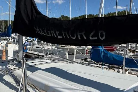 Slide: The Image of 1996 McGregor 26 sailboat docked in a marina under a clear blue sky. - 2